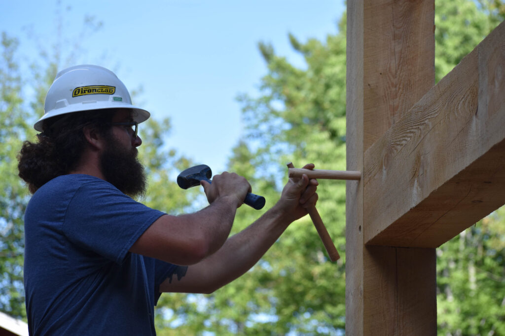 timber-frame-joinery-14 Jake using oak pegs to secure mortise and tenon